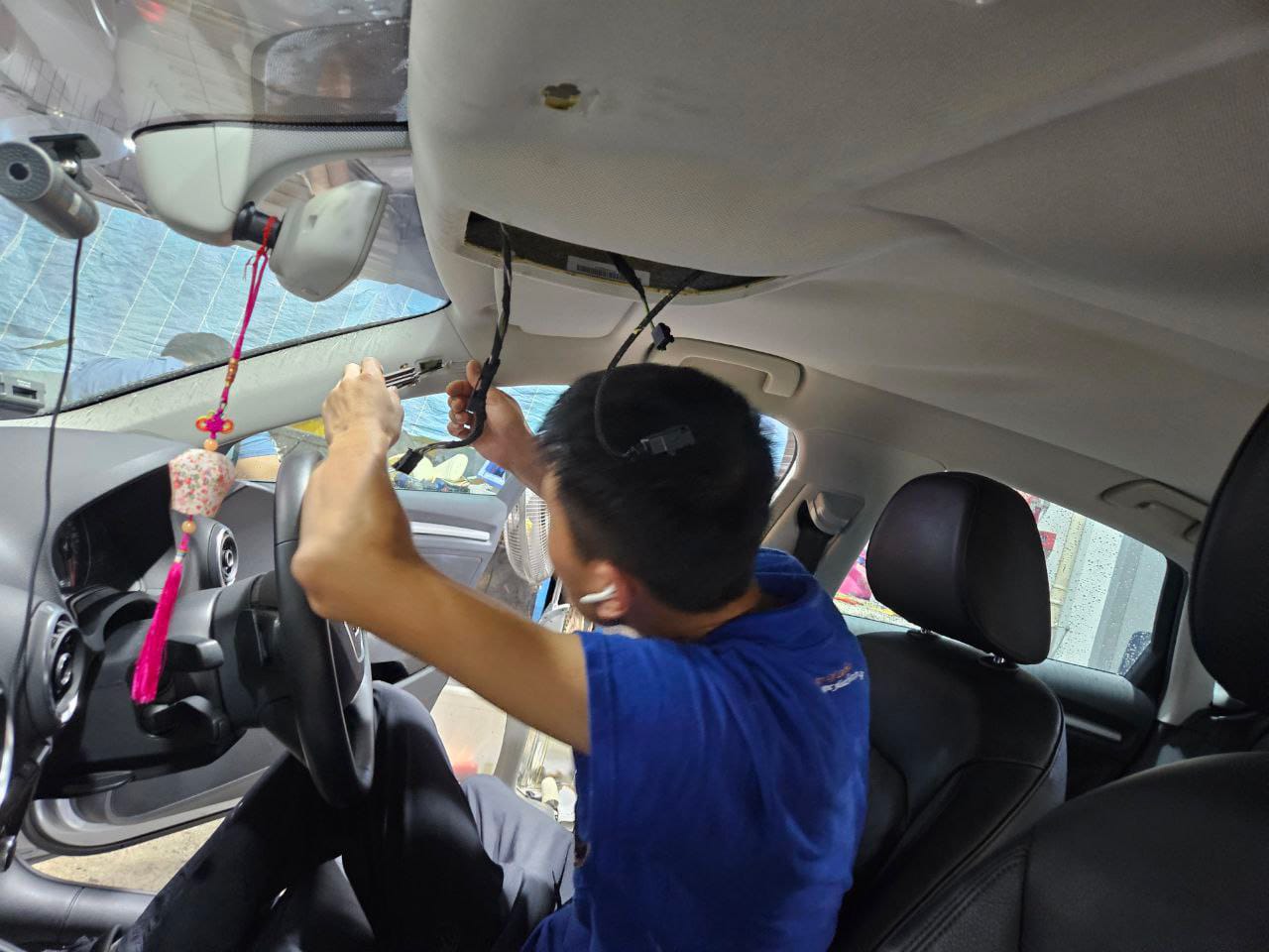 Technician removing a damaged car roof lining in Singapore