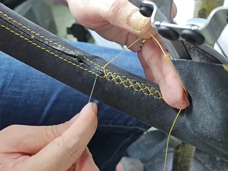 Car Interior Restoration Singapore - hand-stitching a steering wheel with precision, carefully sewing each stitch to ensure a perfect finish.