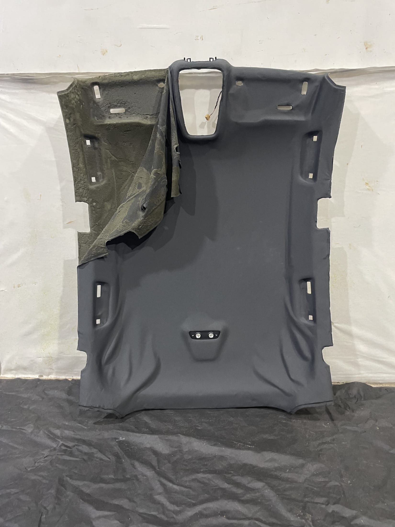 Removed Audi S5 Sportback F5 black headliner with detached fabric before repair