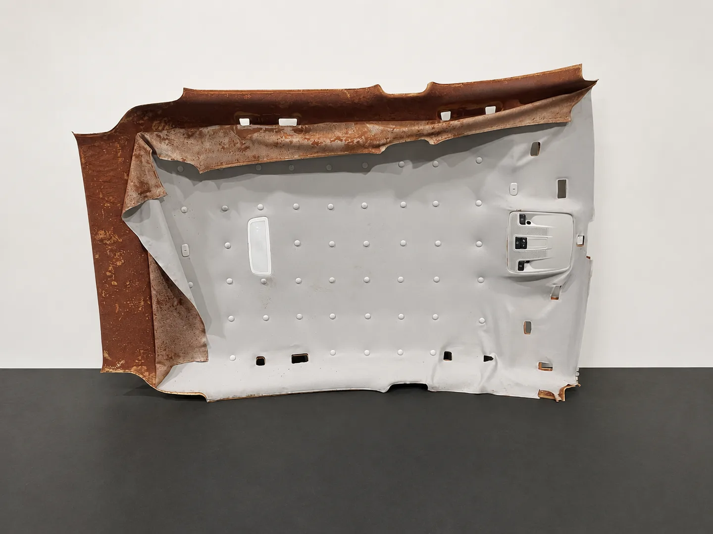 Illustration showing plastic pins holding loose headliner fabric over deteriorated foam