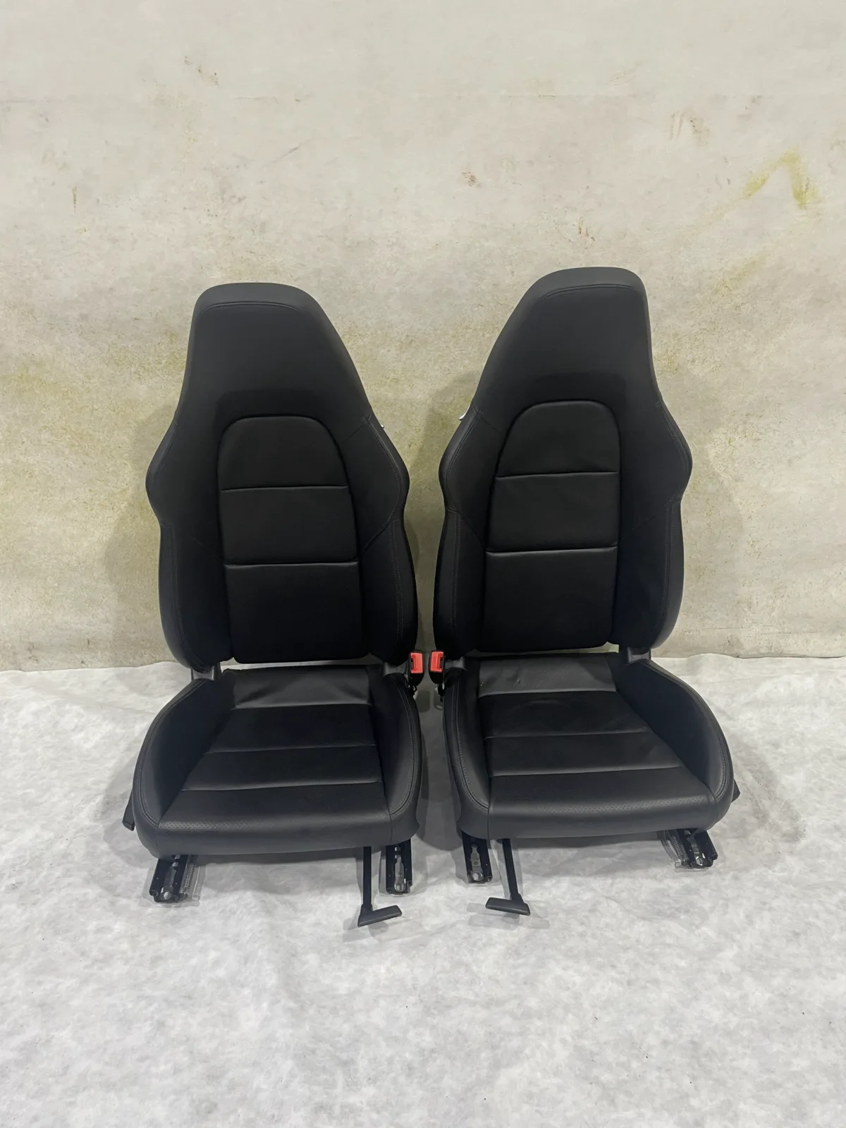 Original black Porsche Cayman 981 front seats removed before upholstery replacement