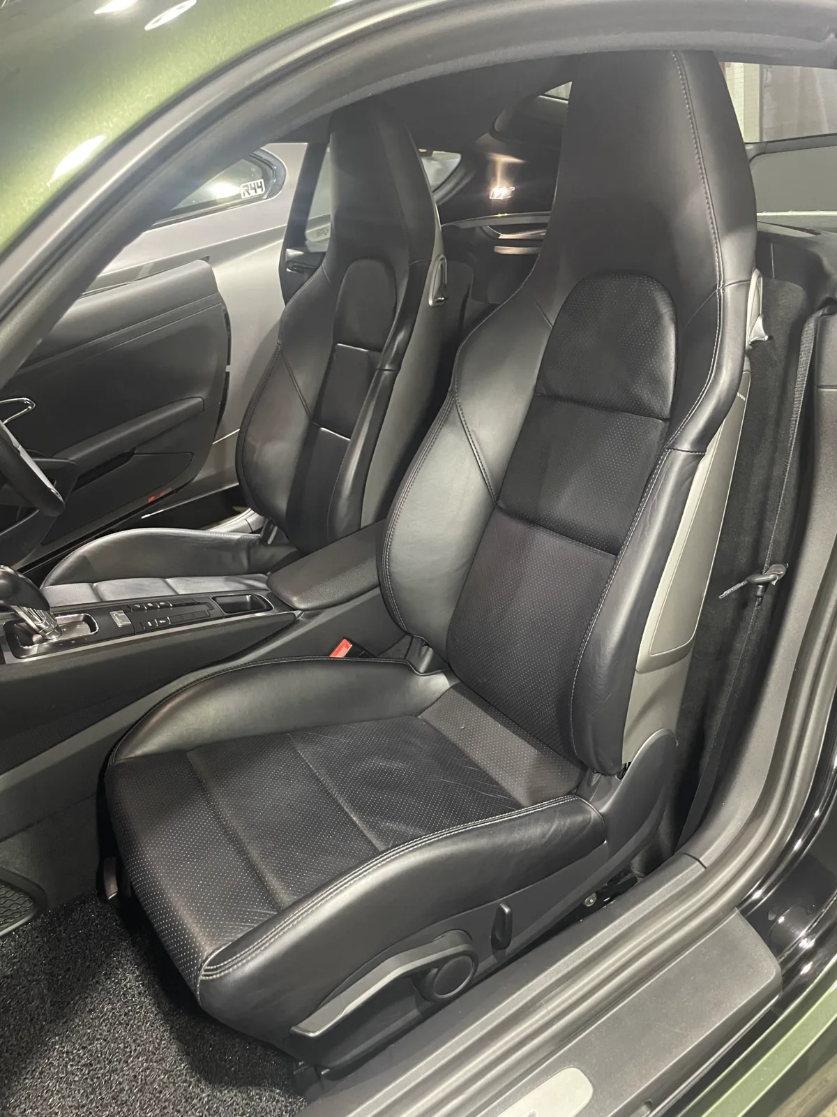 Original all-black Porsche Cayman 981 front seats installed before reupholstery