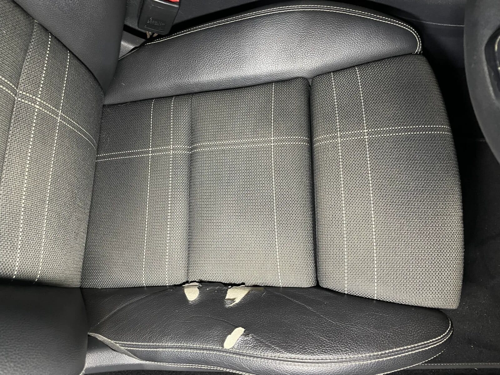 Angled view of damaged outer seat bolster before repair